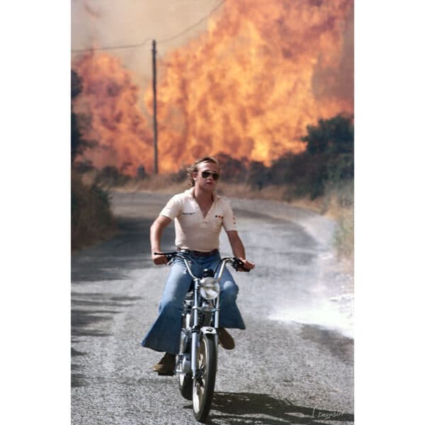 Photo d'un homme à mobilette pendant l'incendie de Villanova en Corse